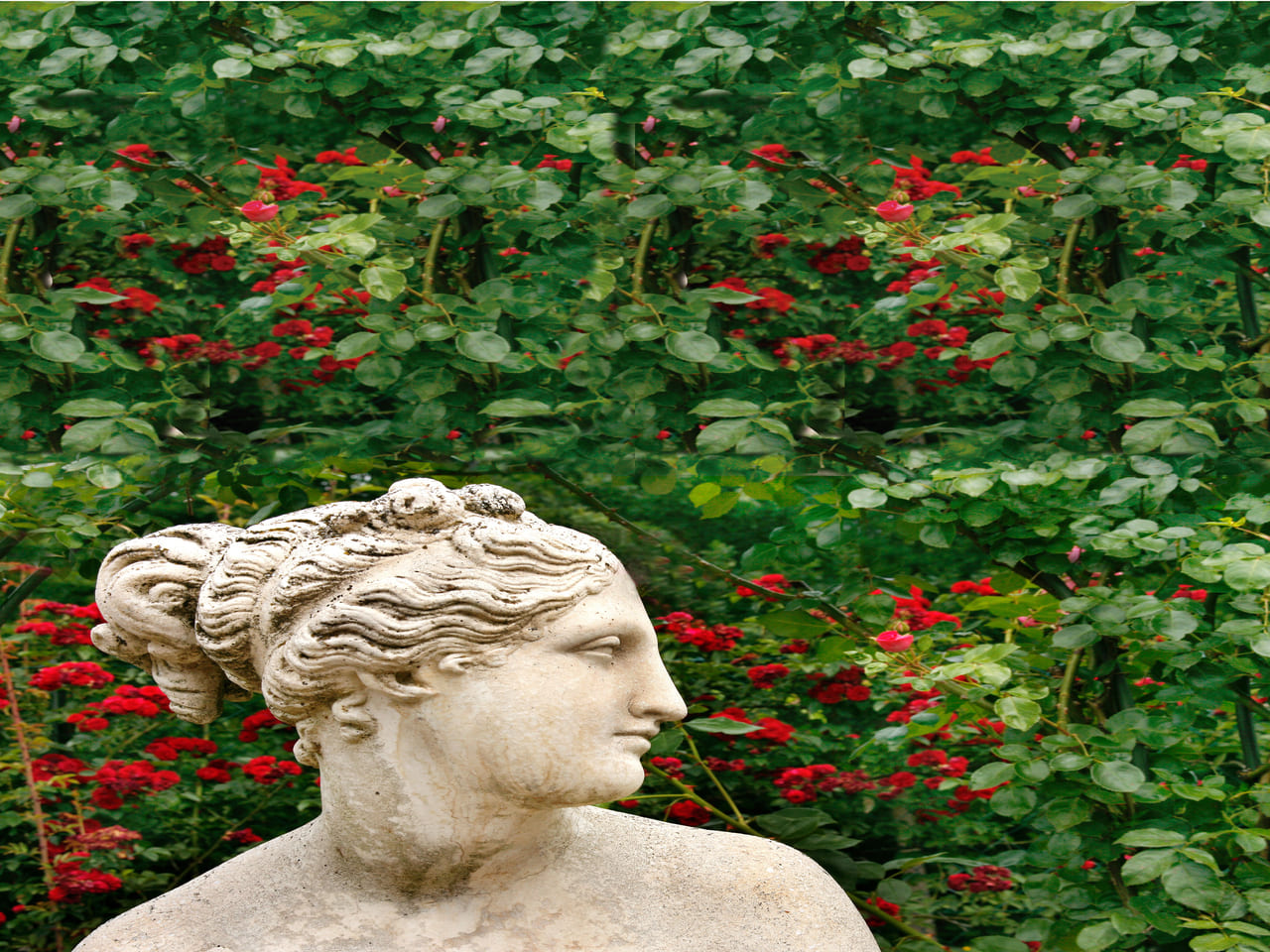 Estatua grecorromana sobre un fondo de plantas y flores. 